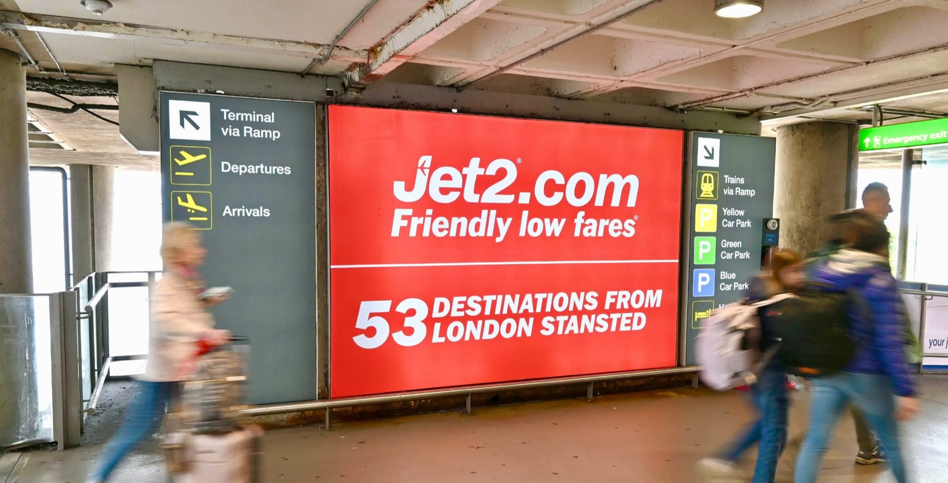 Airport terminal advertising screens and panels in a UK departure lounge