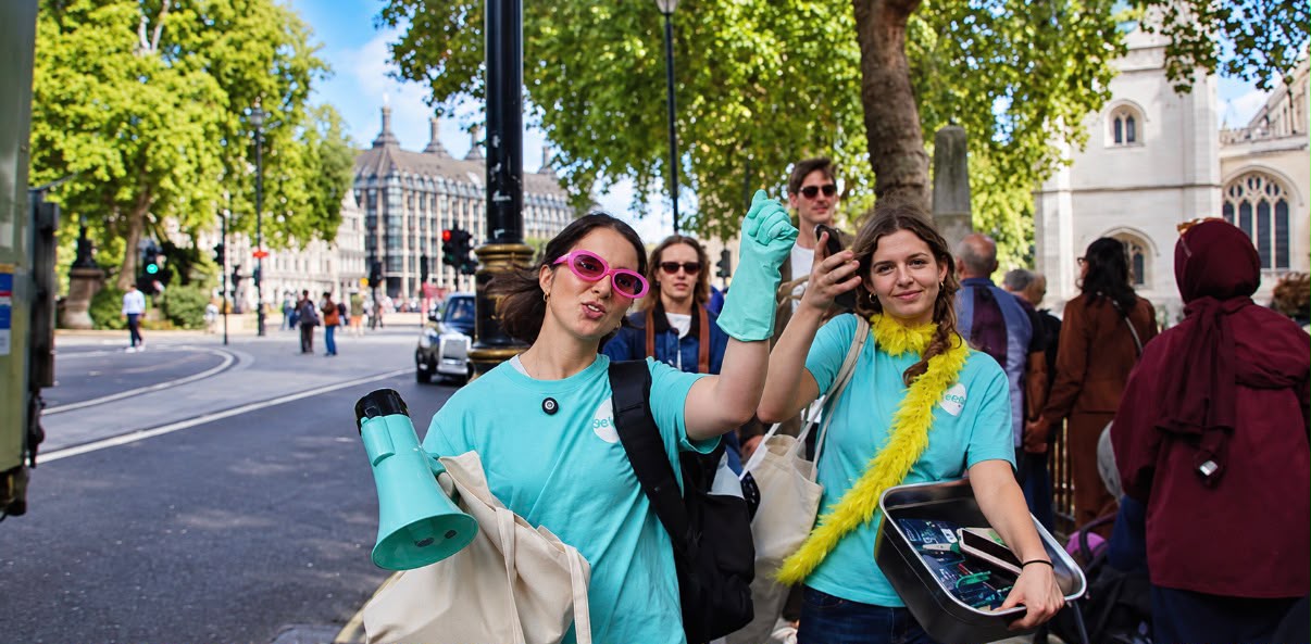 Seep brand ambassadors in teal t-shirts giving away branded sponges in Parliament Square, London, with the Houses of Parliament behind them